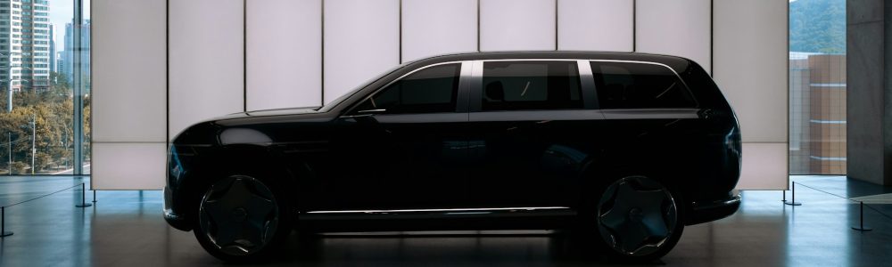 Black executive SUV parked in front of modern corporate building for close protection detail.